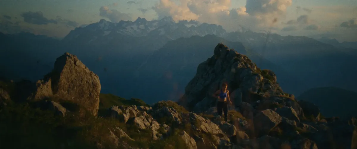 Coût d'un film publicitaire en Suisse, illustré par un tournage en montagne avec un coureur dans un paysage alpin.