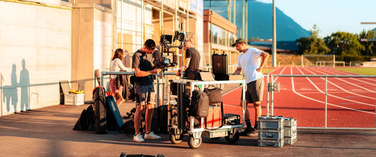 Camera crew preparing equipment and camera rig on set during a commercial film production shoot