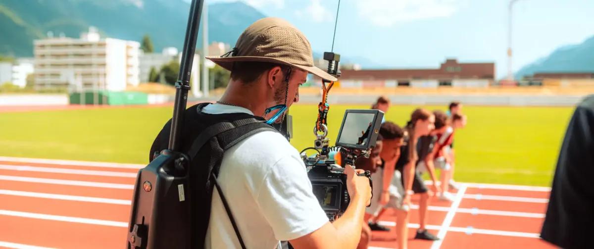 Bruno Perrin, director of photography, filming a commercial on a professional film set in Switzerland with athletes on a running track