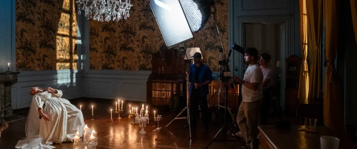 Film production company in Switzerland on set with crew, lighting setup, and staged scene during a professional shoot.